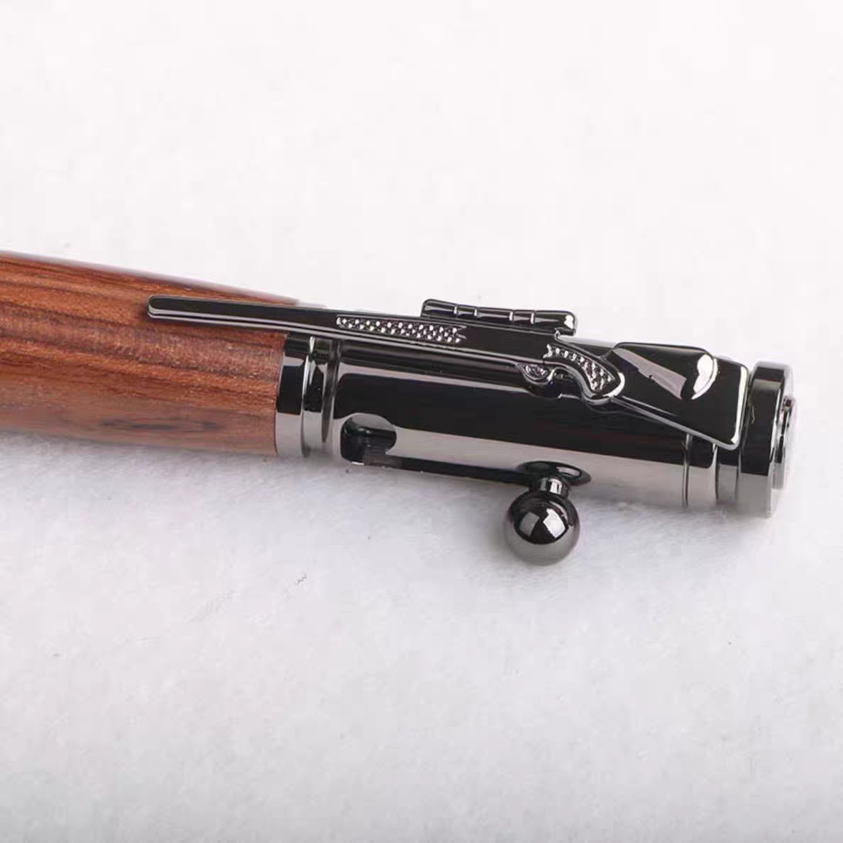 Close detail of the bolt action mechanism on the wooden writing pen